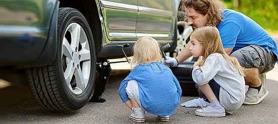 Pappa och barn byter hjul